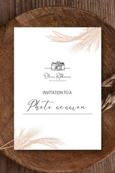 the wedding stationery is laid out on top of a wooden plate with some feathers