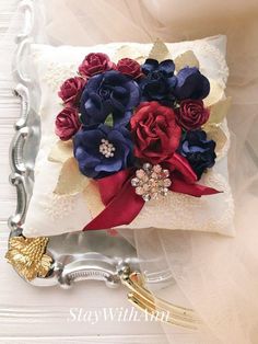 a decorative pillow with red, white and blue flowers on it sitting on a table