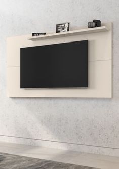 an entertainment center with a flat screen tv mounted on it's side, in front of a white wall