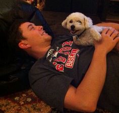 a man laying on the floor with his dog