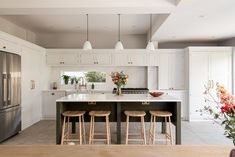 a kitchen island with four stools in front of it