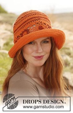 a woman with red hair wearing an orange crochet hat and looking at the camera