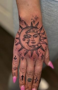 a woman's hand with tattoos on it and a sun tattooed on the palm