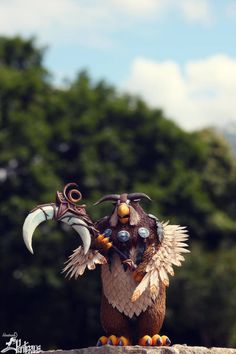 a statue of a bird with horns and feathers on it's head