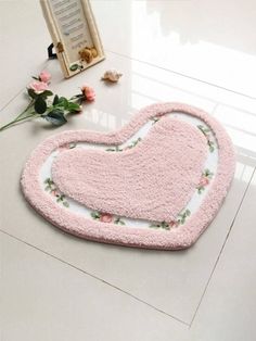 a pink heart shaped rug sitting on top of a table