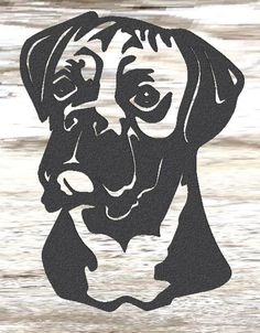 a black and white dog is shown in the shape of a face on a wooden surface