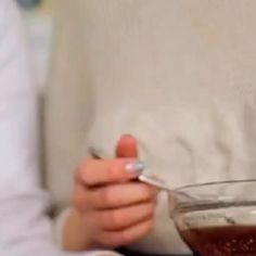 a person holding a spoon in a glass bowl