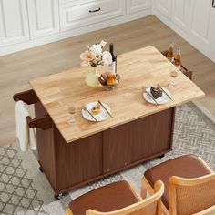 a kitchen table with two chairs and a vase on it, next to the counter