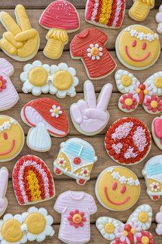 many decorated cookies on a wooden table with flowers and other items in the shape of people