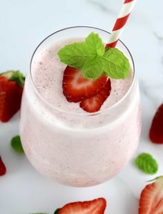 a smoothie with strawberries and mint on the side