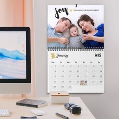 a desktop computer sitting on top of a desk next to a calendar and mouse with a family photo