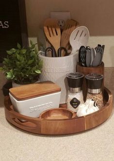 a wooden tray with utensils and other kitchen items