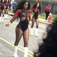 several women in bodysuits and boots are dancing on the street