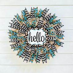 a wreath with the word hello painted on it in black and white chevrons