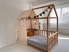 a bed with a wooden frame and canopy in a room that has white carpeting