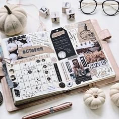 an open planner book sitting on top of a table next to pumpkins and other items