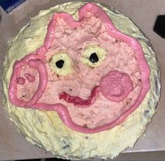 a cake that looks like a face with pink icing on it