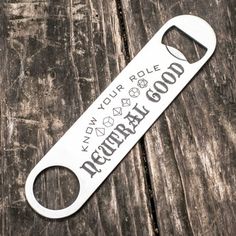 a bottle opener with the words happy hour hole on it sitting on a wooden table