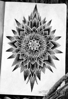 a black and white drawing of a flower on a piece of paper next to pencils