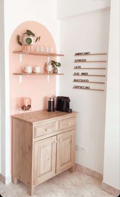 a wooden cabinet sitting in the corner of a room with shelves and cups on it