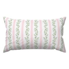 a pink and white striped pillow with green leaves on the front, along with a light pink stripe