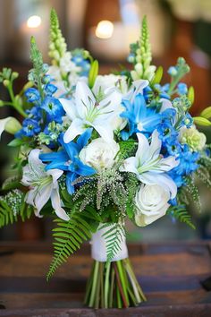 blue and white flowers in a vase on a table