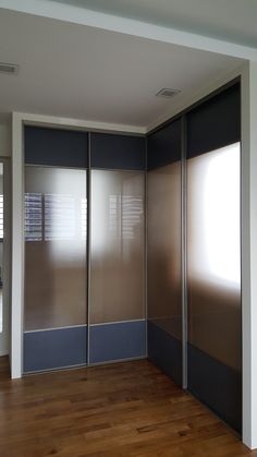 an empty room with sliding doors and hard wood flooring