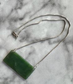 Hand-carved from jade harvested from under the waves off the Big Sur coast, this one-of-a-kind pendant comes on a 16-inch silver chain. Silver Carved Jade Jewelry, Carved Silver Jade Jewelry, Green Polished Pendant Necklace, Green Pendant Necklace With Polished Finish, Engraved Jade Necklaces For Gifts, Engraved Jade Necklace Gift, Engraved Jade Necklace For Gift, Gift Engraved Jade Necklaces, Carved Jade Pendant Necklace