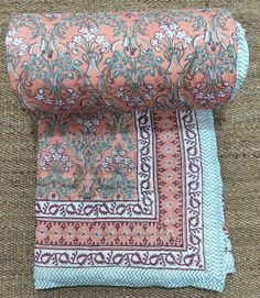 two pieces of fabric sitting on top of a carpet covered in brown and blue material