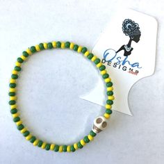 Orula Orunmila Stretchy Bracelet with Skulls Ilde de Orula Adjustable Yellow Wooden Beaded Bracelets, Handmade Casual Skull Bracelets, Handmade Casual Skull Bracelet, Casual Handmade Skull Bracelets, Adjustable Handmade Skull Bracelets, Handmade Skull Bracelet As A Gift, Green Beaded Bracelets With Letter Beads For Festivals, Relative Care, Stretchy Beaded Bracelet