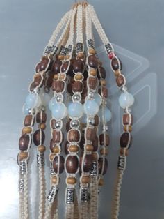 a beaded necklace with beads and glass beads on the end is hanging from a string