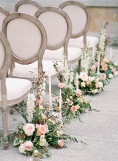 rows of chairs lined up with flowers and candles