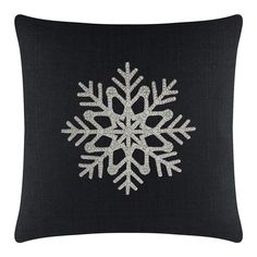 a black pillow with white snowflakes on it