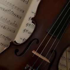 an old violin with sheet music in the background