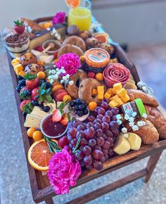 a wooden tray filled with lots of different types of food and drinks on top of a table