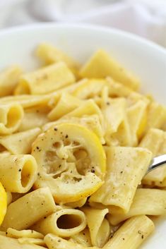 a white bowl filled with pasta and lemon slices