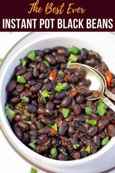 the best ever instant pot black beans in a white bowl with spoons and cilantro