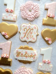 decorated cookies are arranged in the shape of hearts and flowers for a first birthday party