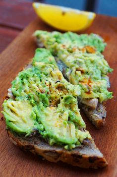 an avocado toast is cut in half on a cutting board