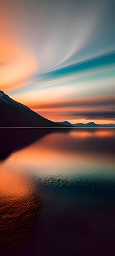 the sky is reflected in the still water at sunset with mountains in the back ground