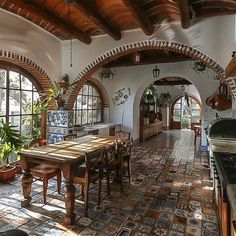 a kitchen with an arched ceiling and tile flooring, along with potted plants