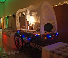 a horse drawn carriage with lights on it's sides in a room filled with tables and chairs