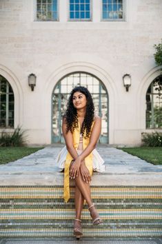 a woman in a yellow dress sitting on some steps