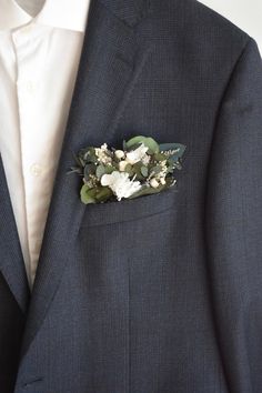 a close up of a suit with flowers on it's lapel pin and tie clip