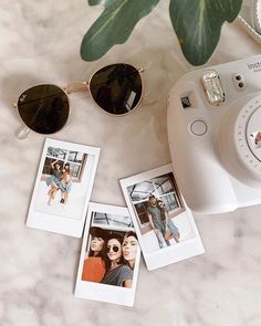 polaroid camera, sunglasses and photos on marble surface