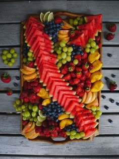 a wooden tray filled with fruit on top of a table