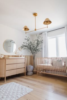 a baby's room with two cribs and a tree in the corner