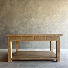 a wooden table with two drawers on it in front of a gray wall and concrete floor