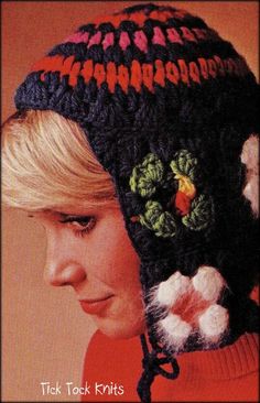 a woman wearing a crocheted hat with flowers on the front and back side