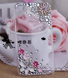 an iphone case with flowers in it on a table next to a pink flower pot